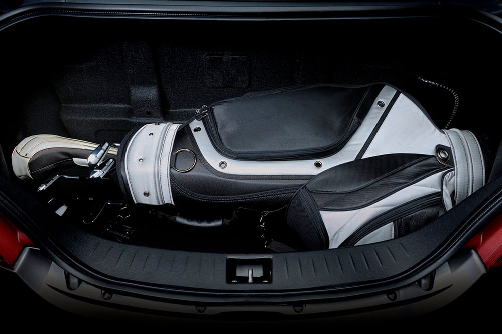 Bolsa de golf tumbada en el maletero de un coche de alquiler